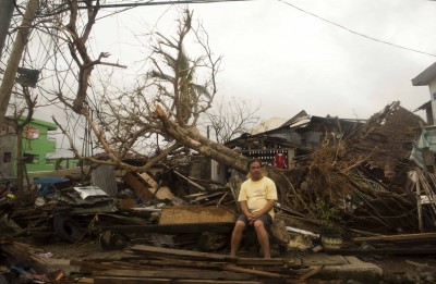 A resident sits on debris in typhoon-hit Leyte Province, Nov. 12, 2013. The United Nations said it had released $25 million in emergency funds to pay for emergency shelter materials and household items, and for assistance with the provision of emergency health services, safe water supplies and sanitation facilities. It's launching an appeal for more aid. (Lui Siu Wai/Xinhua/Zuma Press/MCT)
