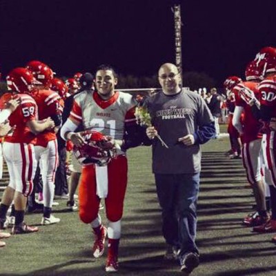Senior Teddy Khnanisho walks down the football field on senior night.