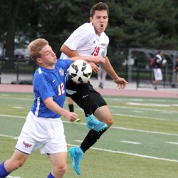 Senior Alen Radeljic attempts to steal the ball midair from Hoffman Estates midfielder in a game last season.